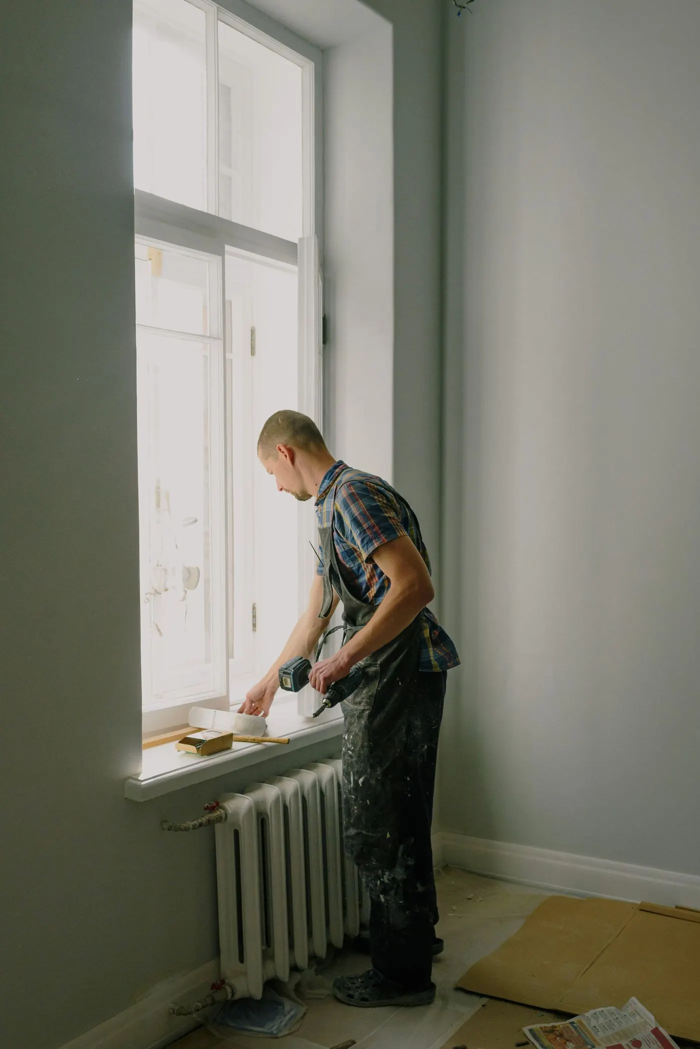 Painter cutting in around a timber sash window