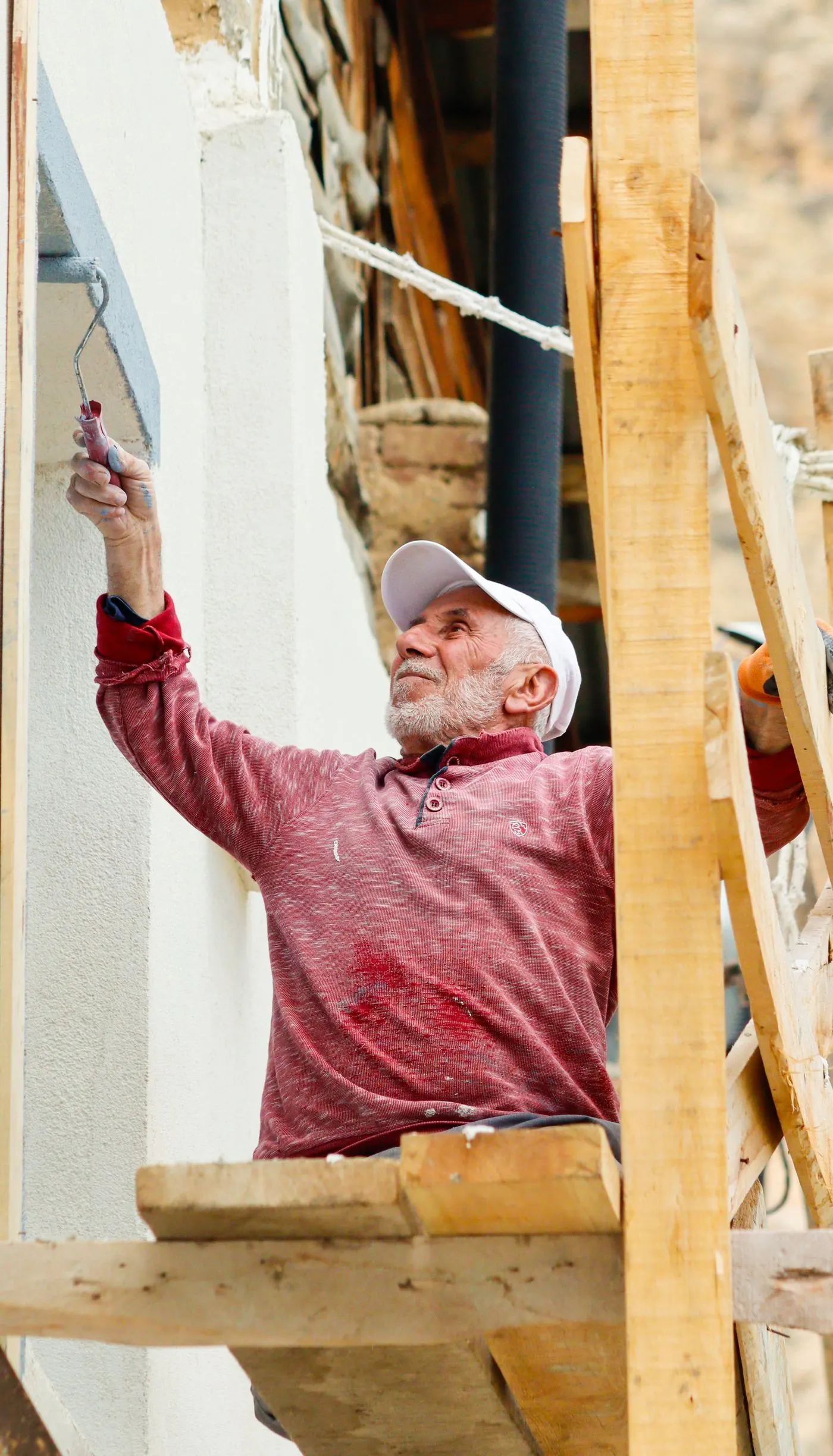 Painter working on an exterior wall from scaffolding