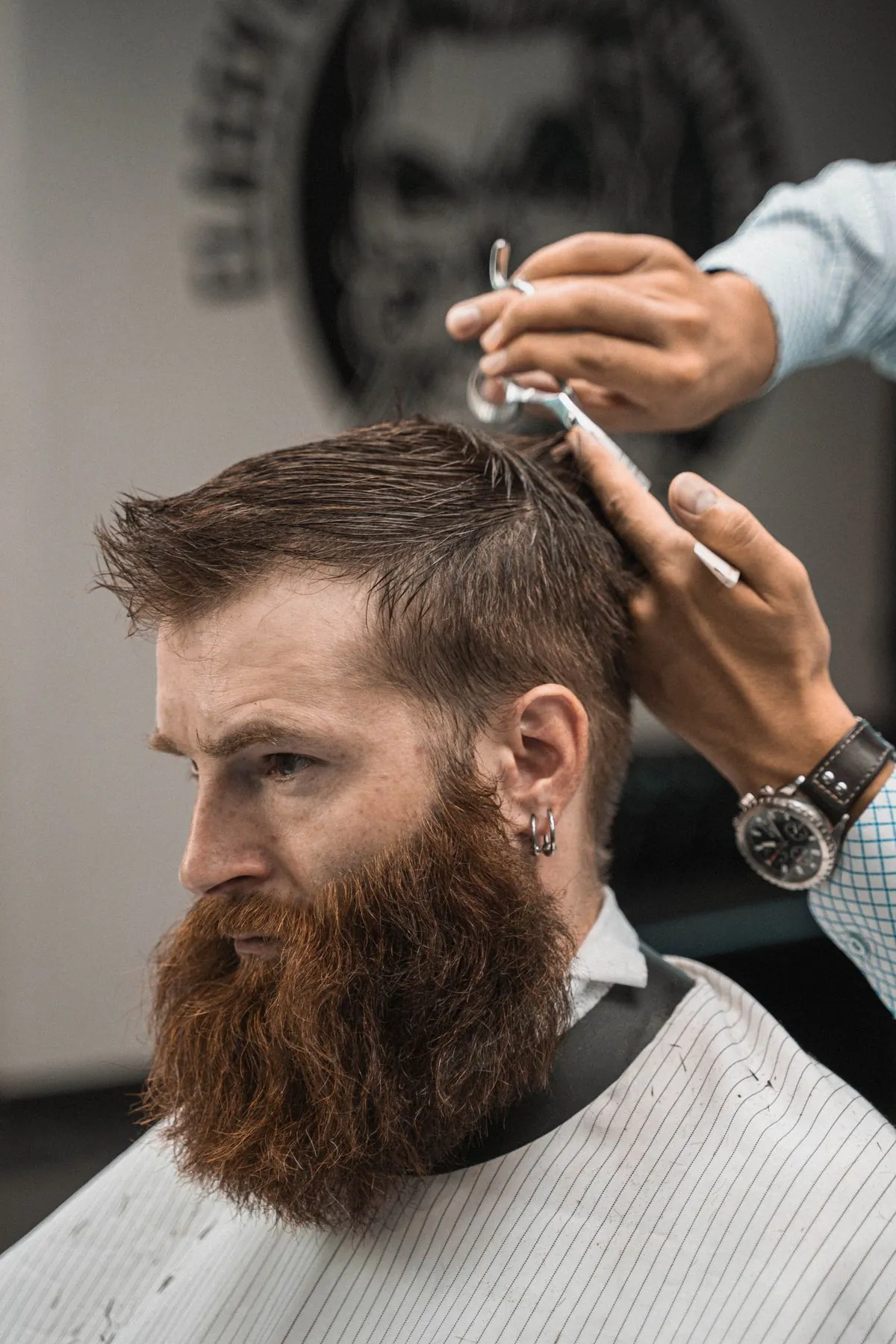Barber styling a bearded client's hair