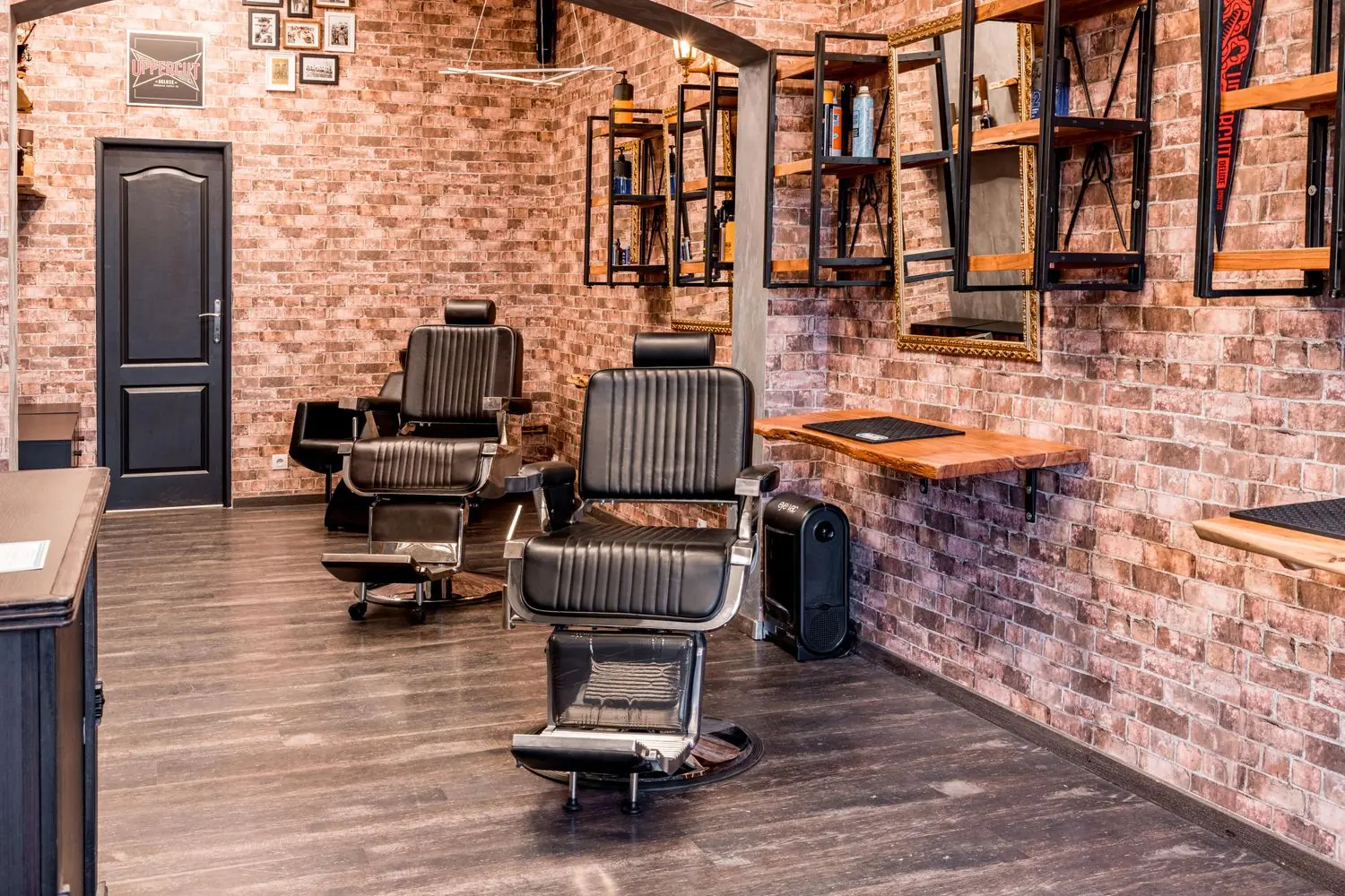 Leather barber chairs against an exposed brick wall